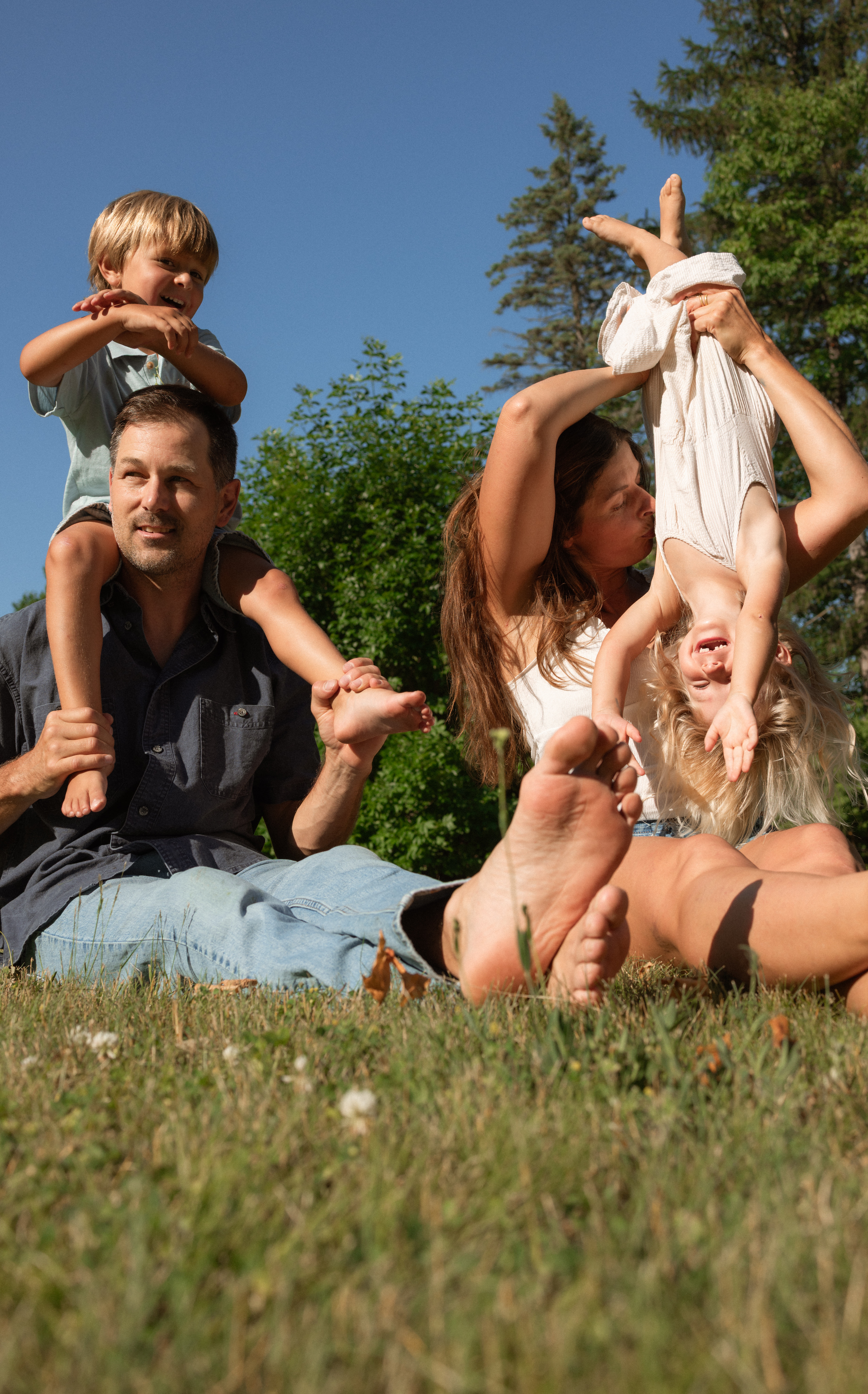 candid moment during backyard family session in ottawa with family of four in the harsh summer light