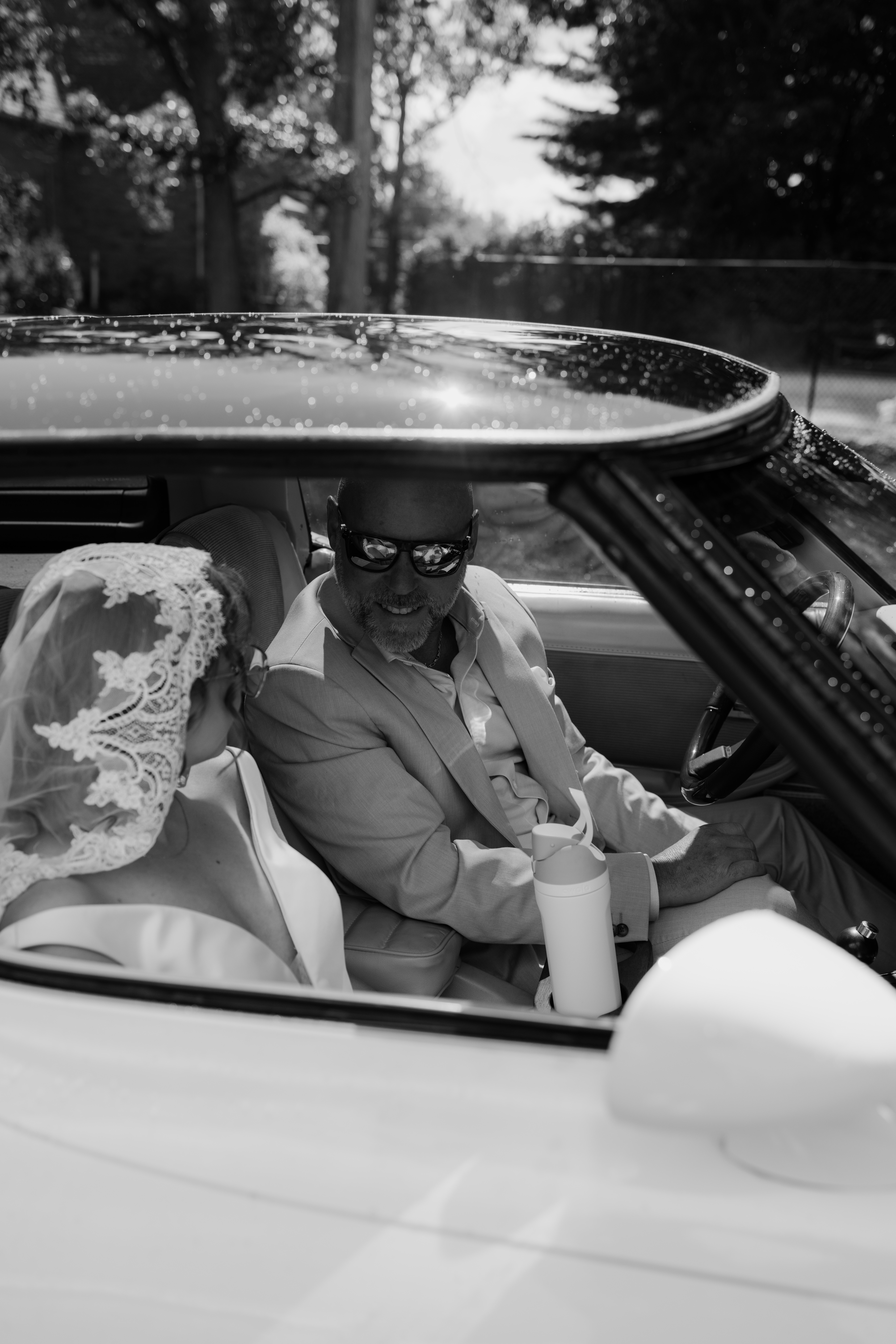 bride and father arriving to ceremony location in vintage car