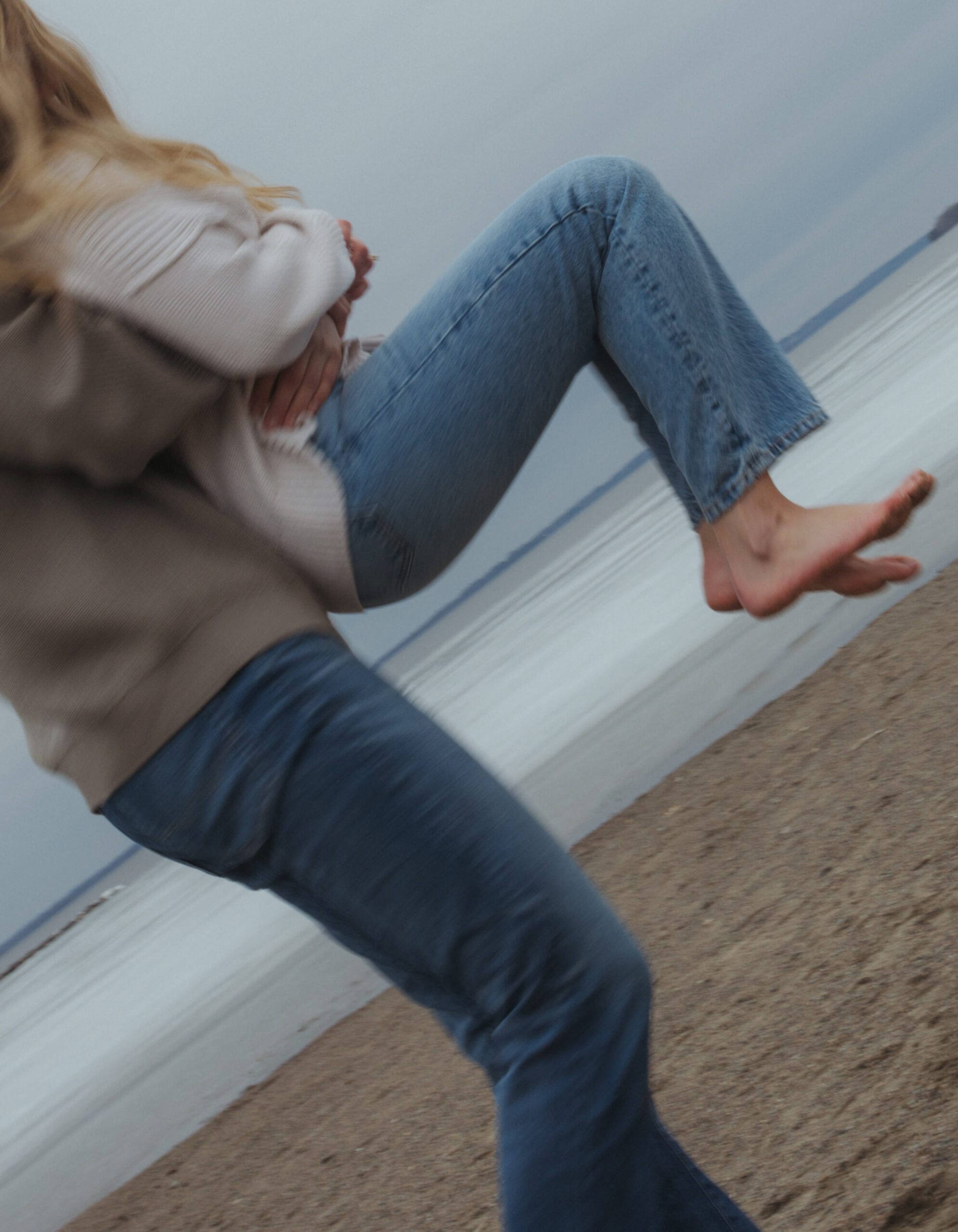 couple spinning on the beach during their spring engagement