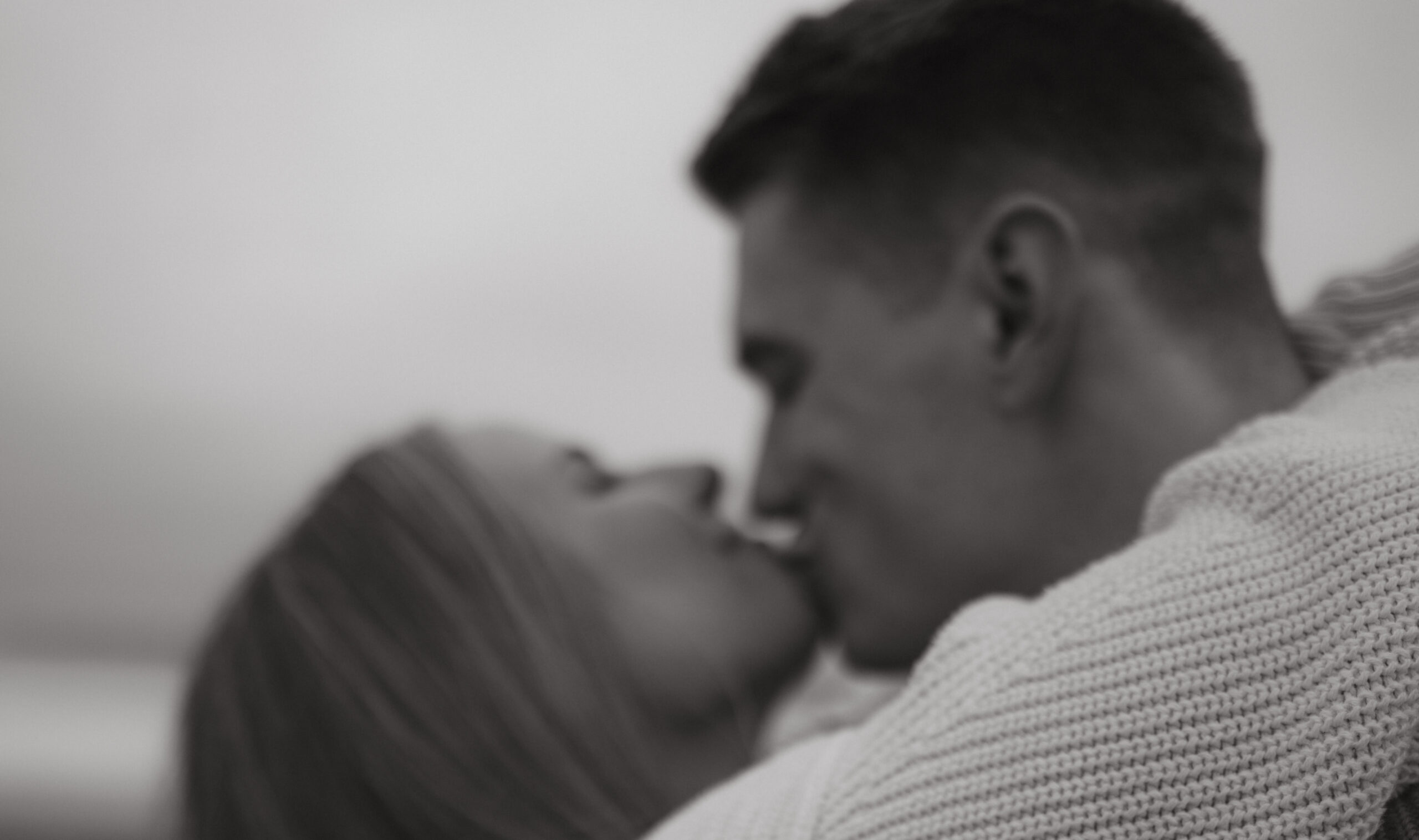 couple kissing in knits on the beach