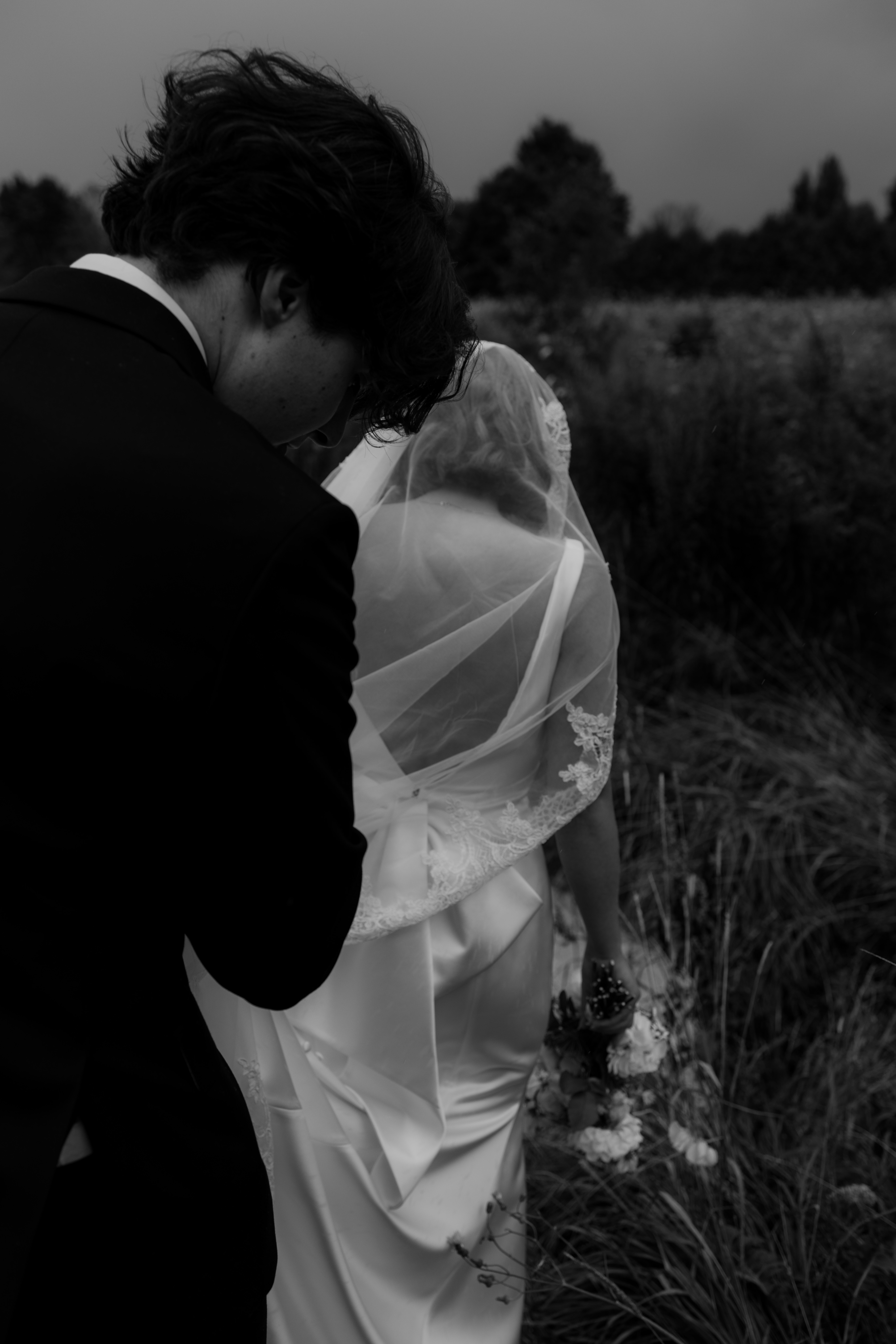 groom holding brides veil