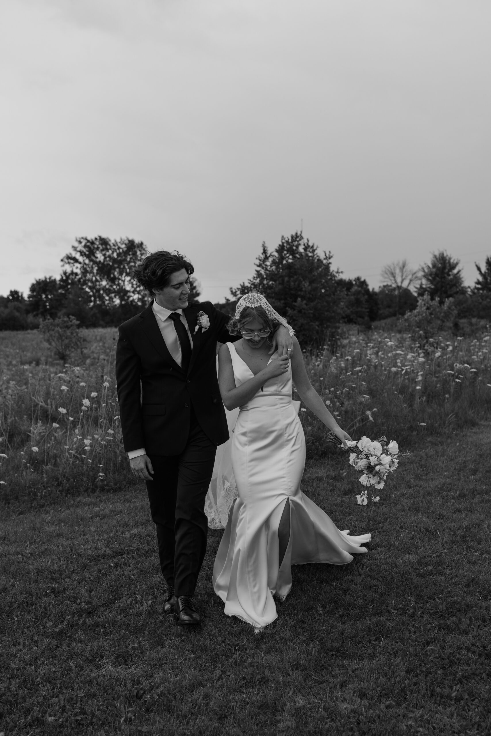 bride and groom laughing as they head to their reception from portraits in a wild flower field 
