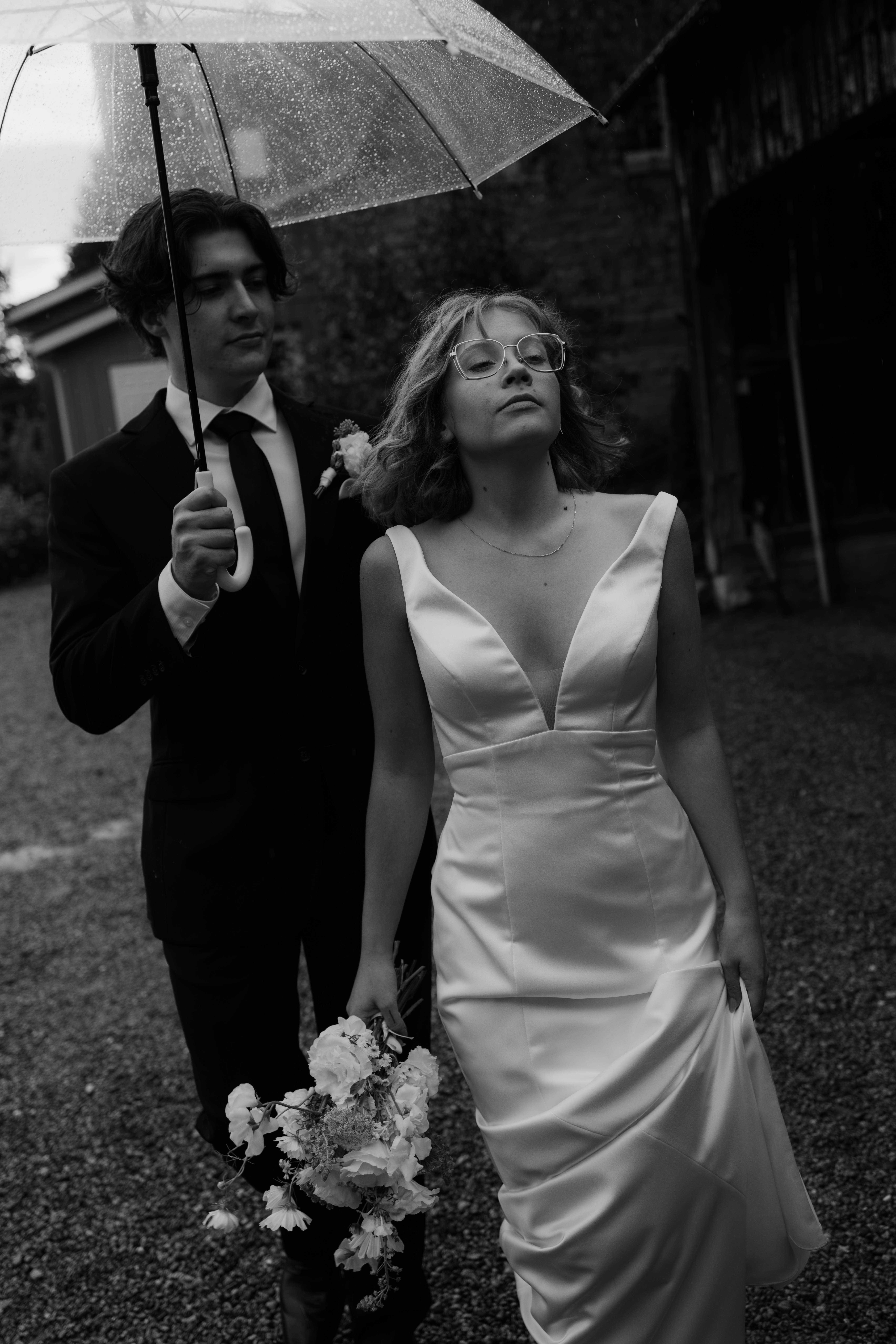 documentary wedding photographer captures couple heading to reception while the rain comes down