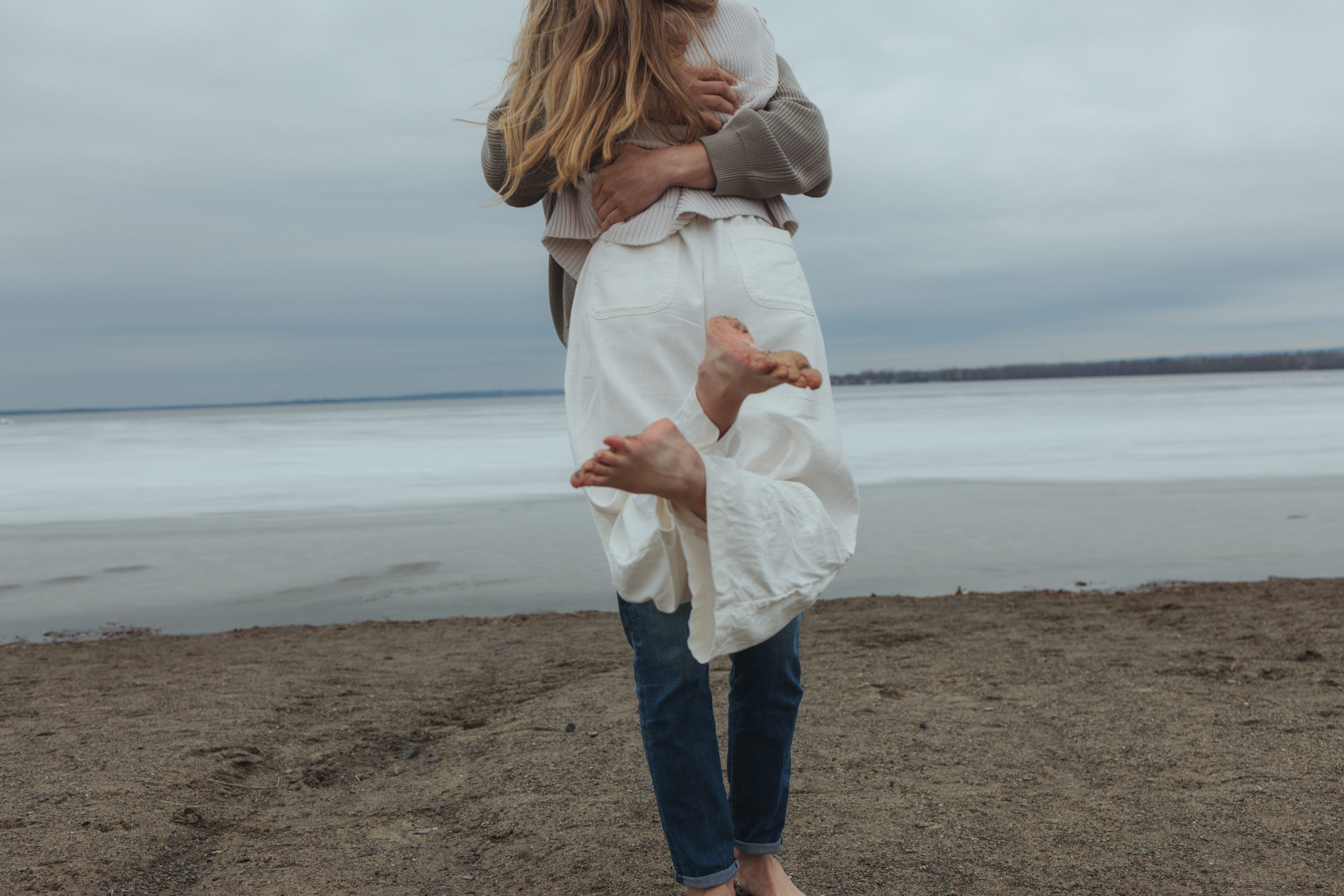 couple spinning during their barefoot beach engagement session