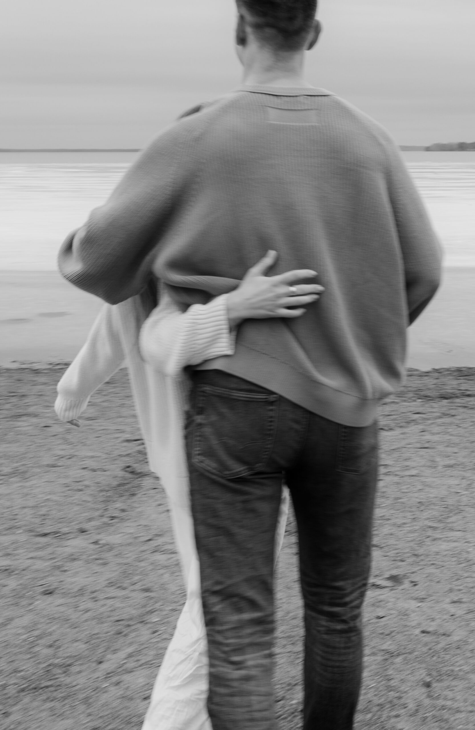 hand around back walking on a beach in the early spring