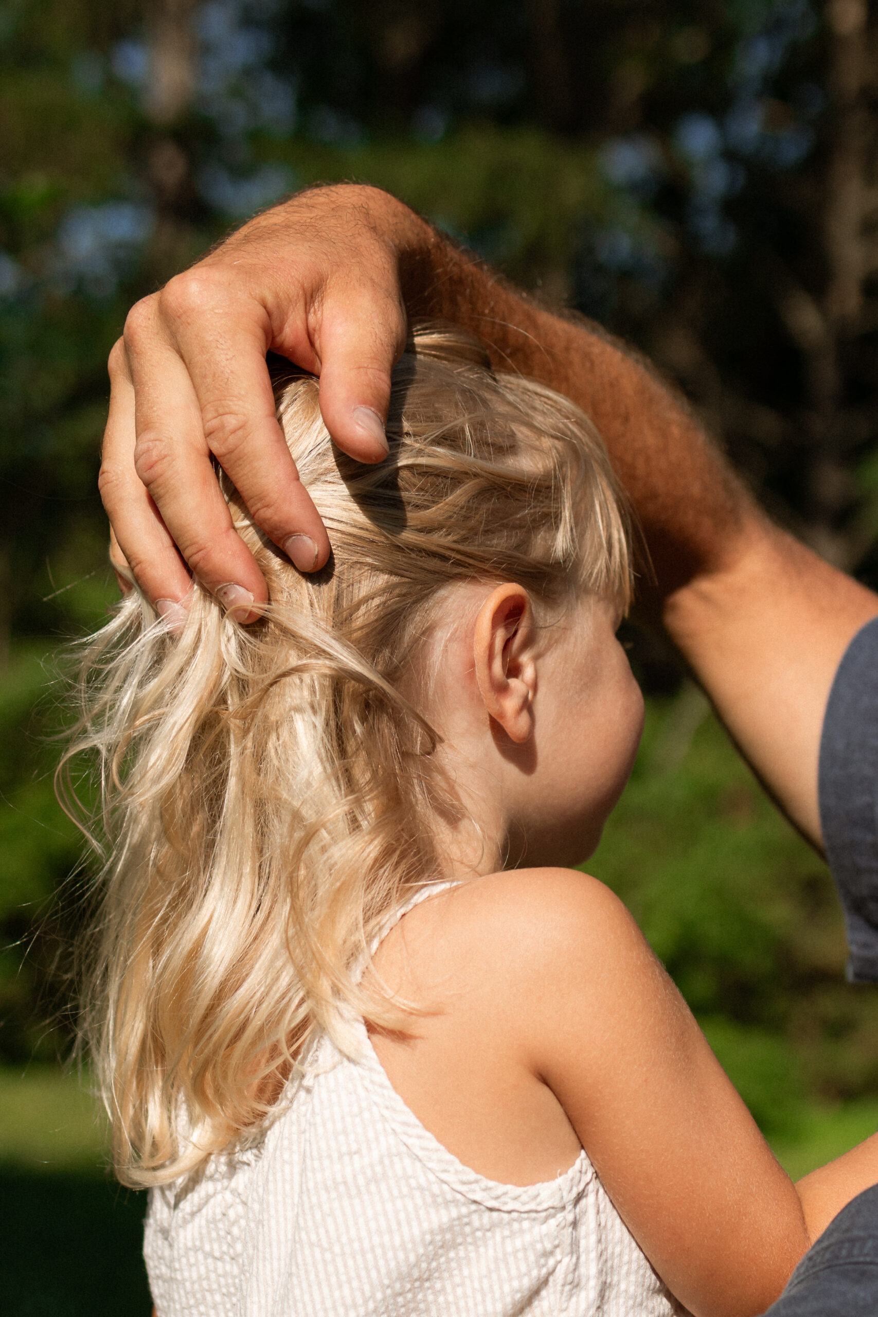 dad brushing daughters hair out of her face 