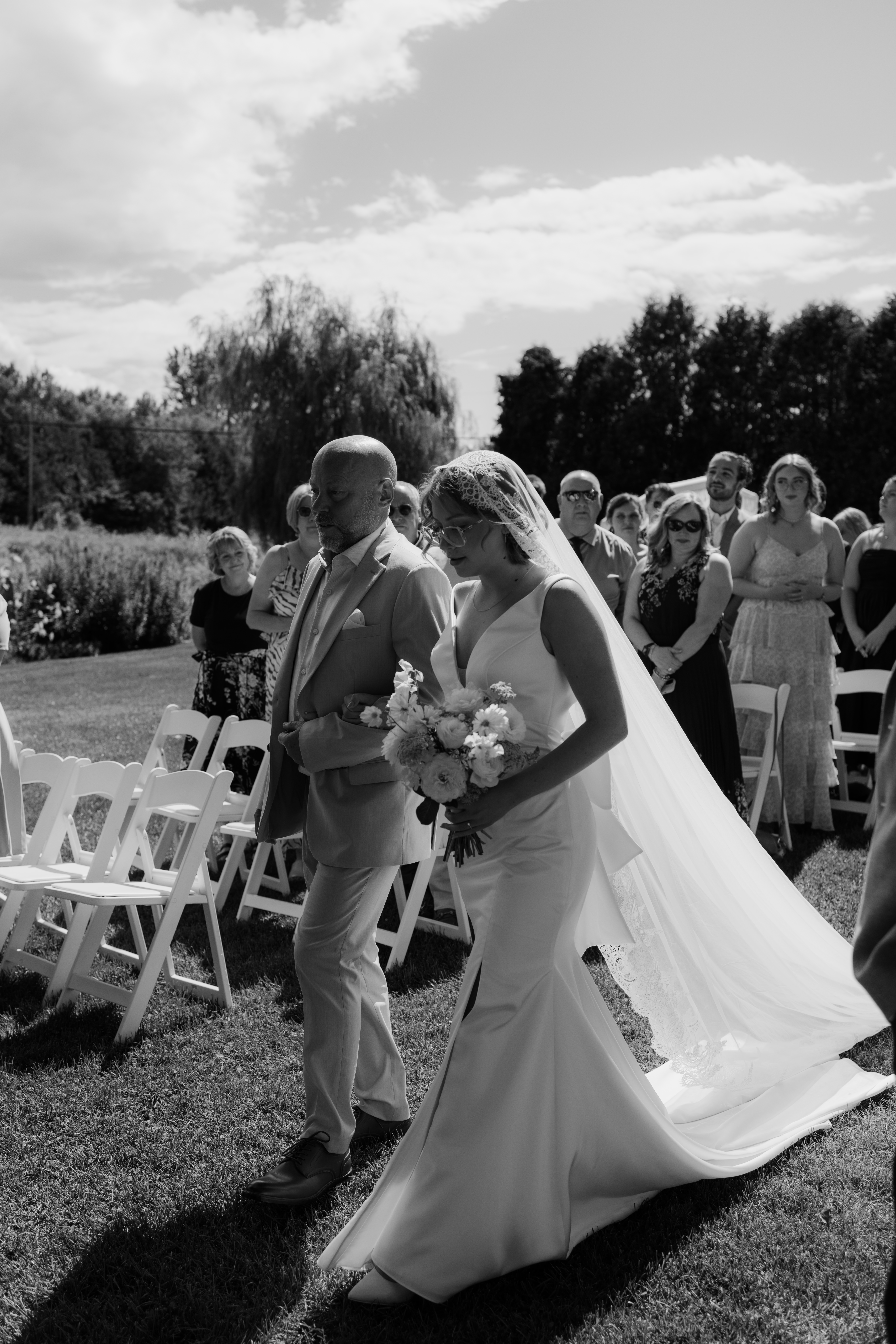 father and daughter walk during outdoor ceremony at chic summer wedding 