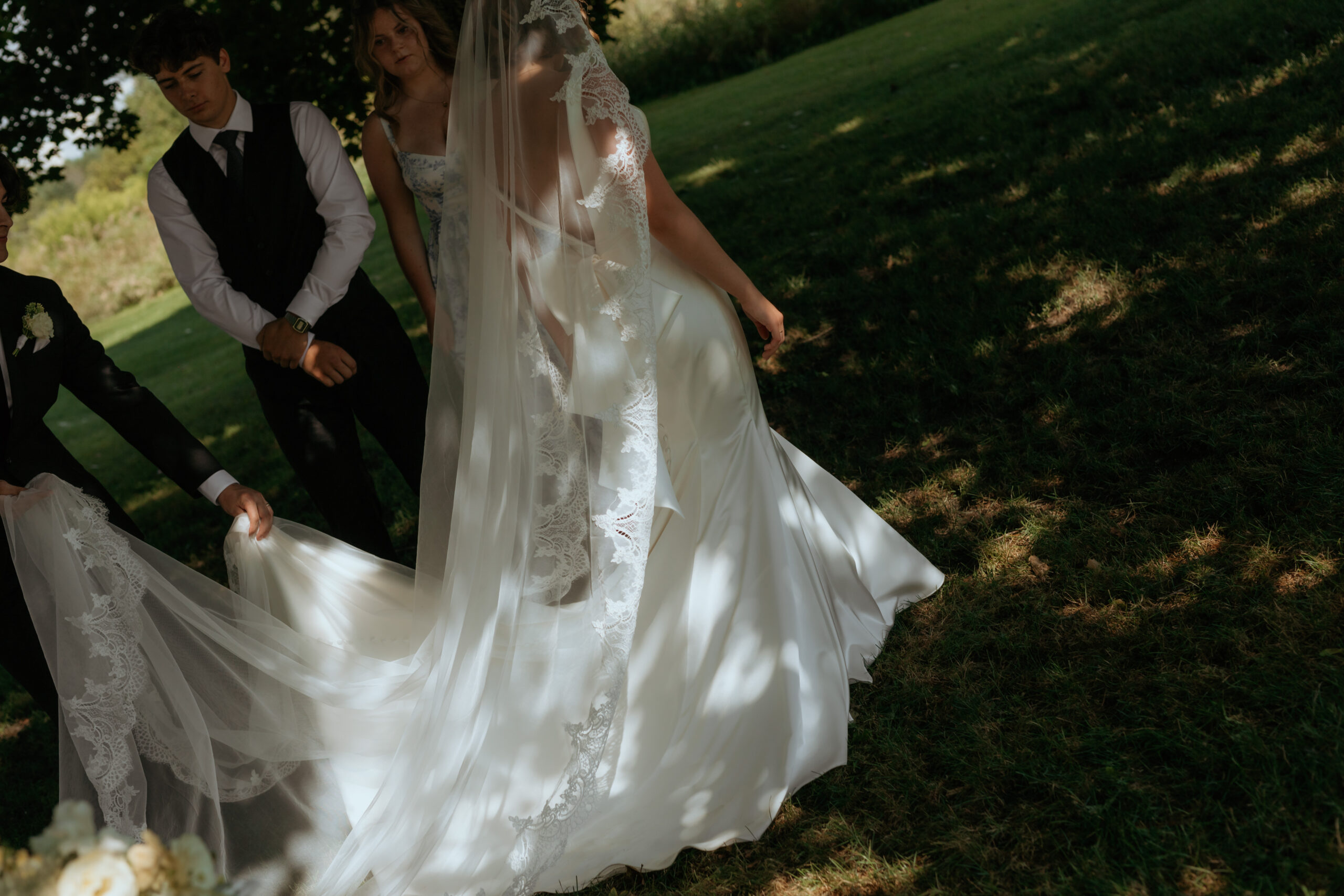 detailed gown glowing as the summer light hits it during ceremony