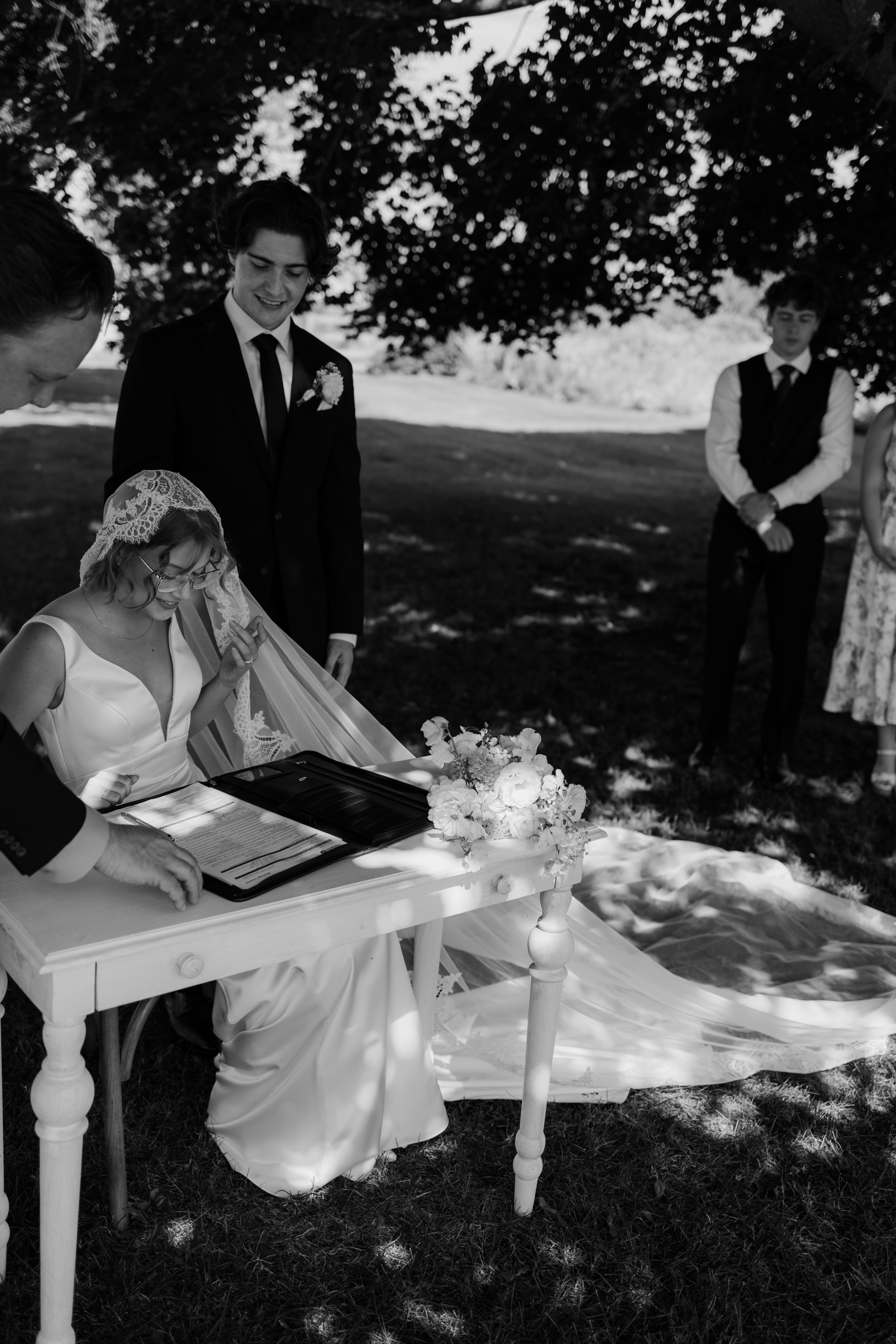 bride and groom signing at their outdoor chic summer ceremony