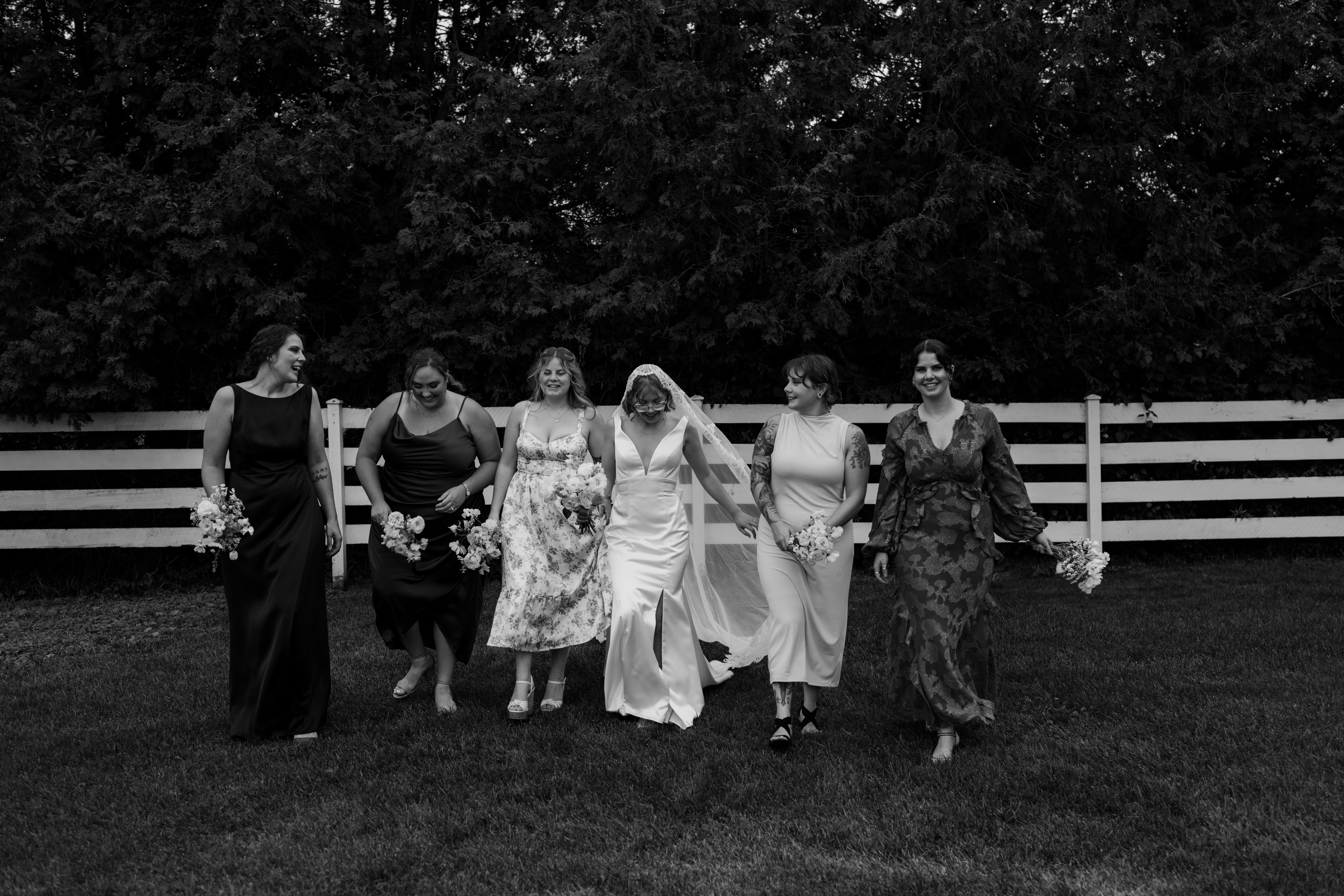 bride and stylish bridesmaids walking toward ottawa wedding photographer