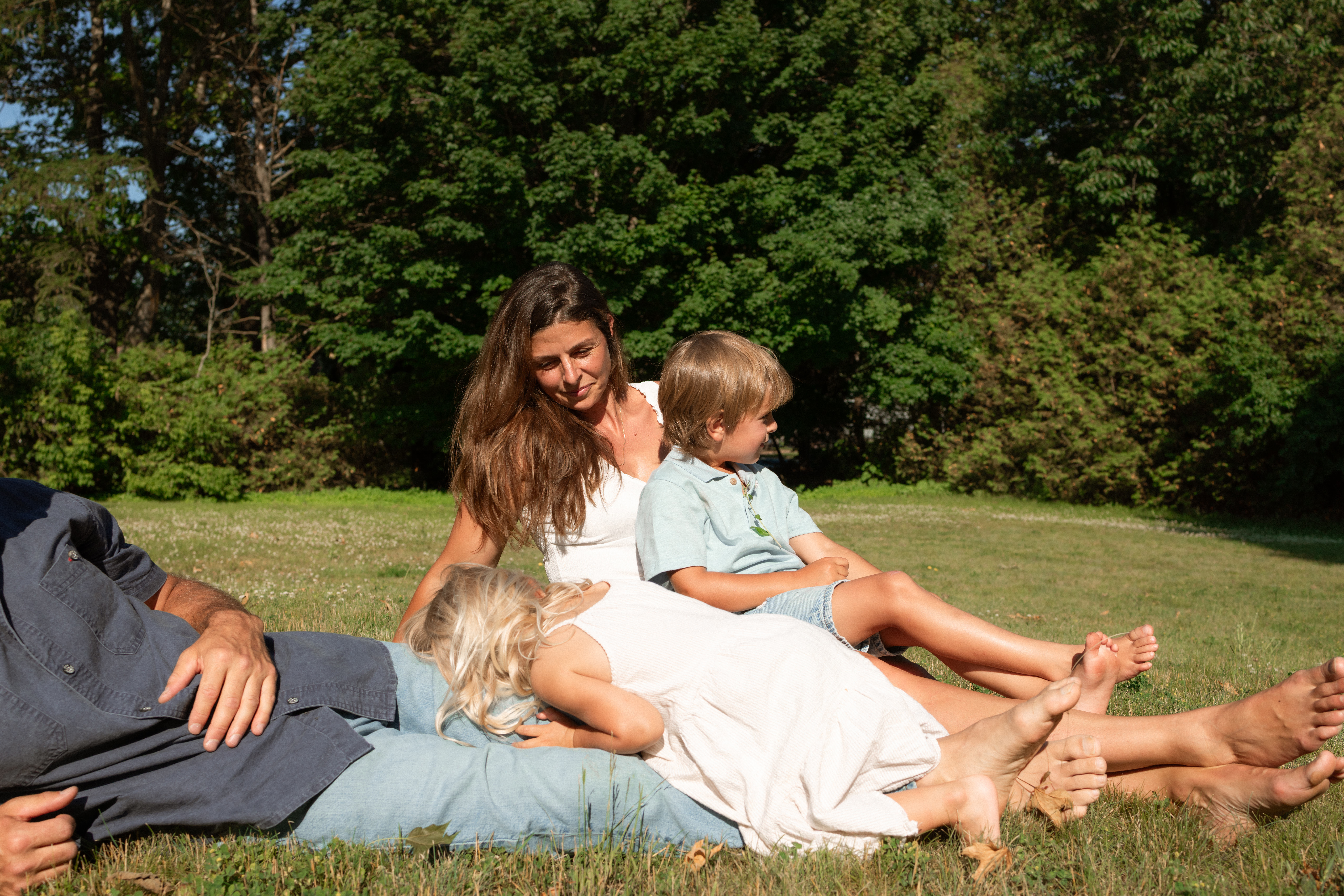 family lays in grass during a documentary family backyard session