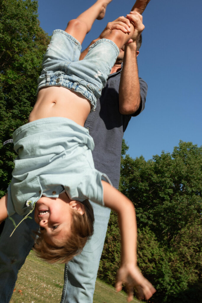 dad playing with son in their backyard during summer family session 