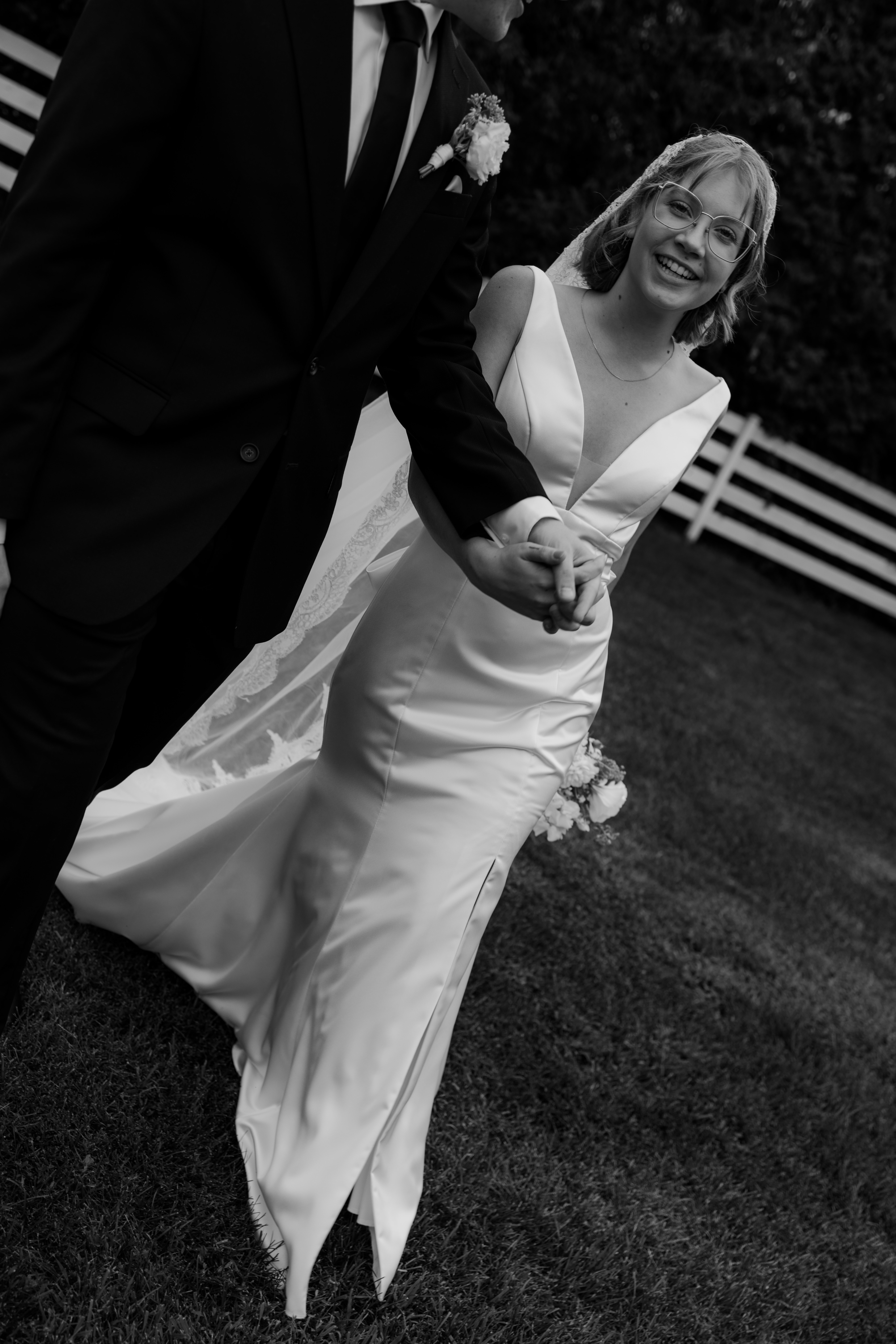 documentary wedding photographer captures candid bride and groom moment as they laugh walking to meet guests 