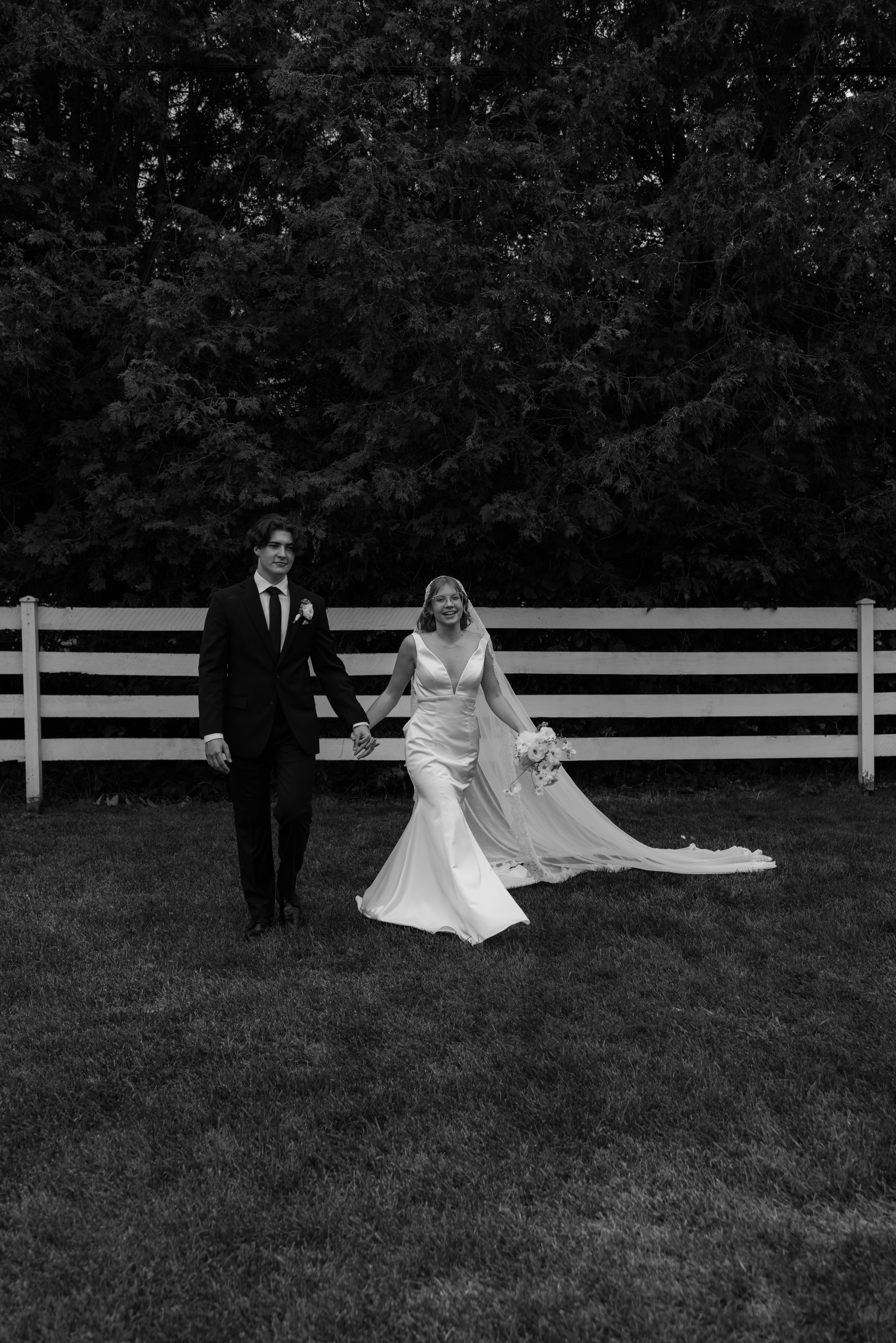 bride and groom laughing while they walk to greet gusts at wedding venue