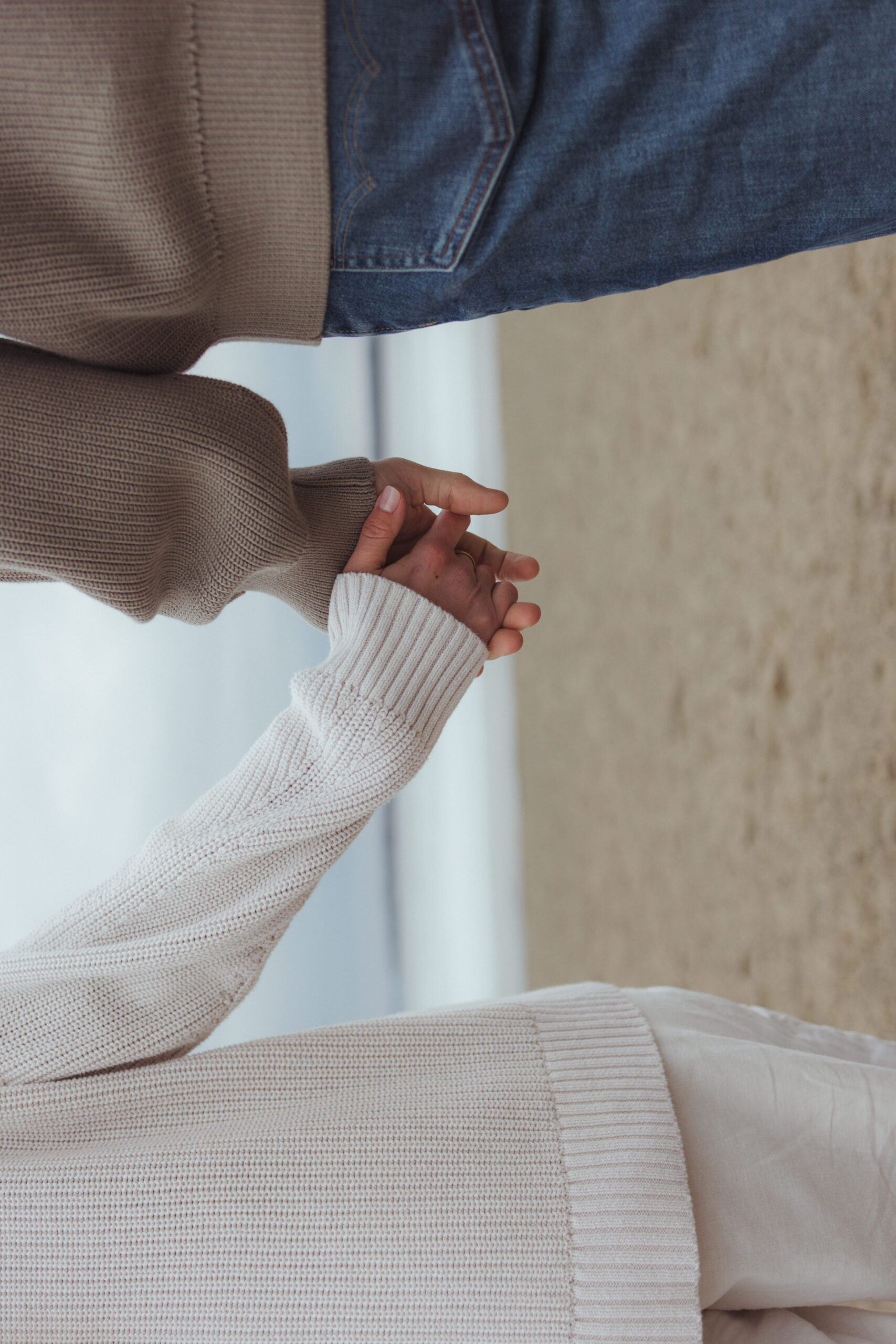 holding hands on the beach during their engagement session in the spring