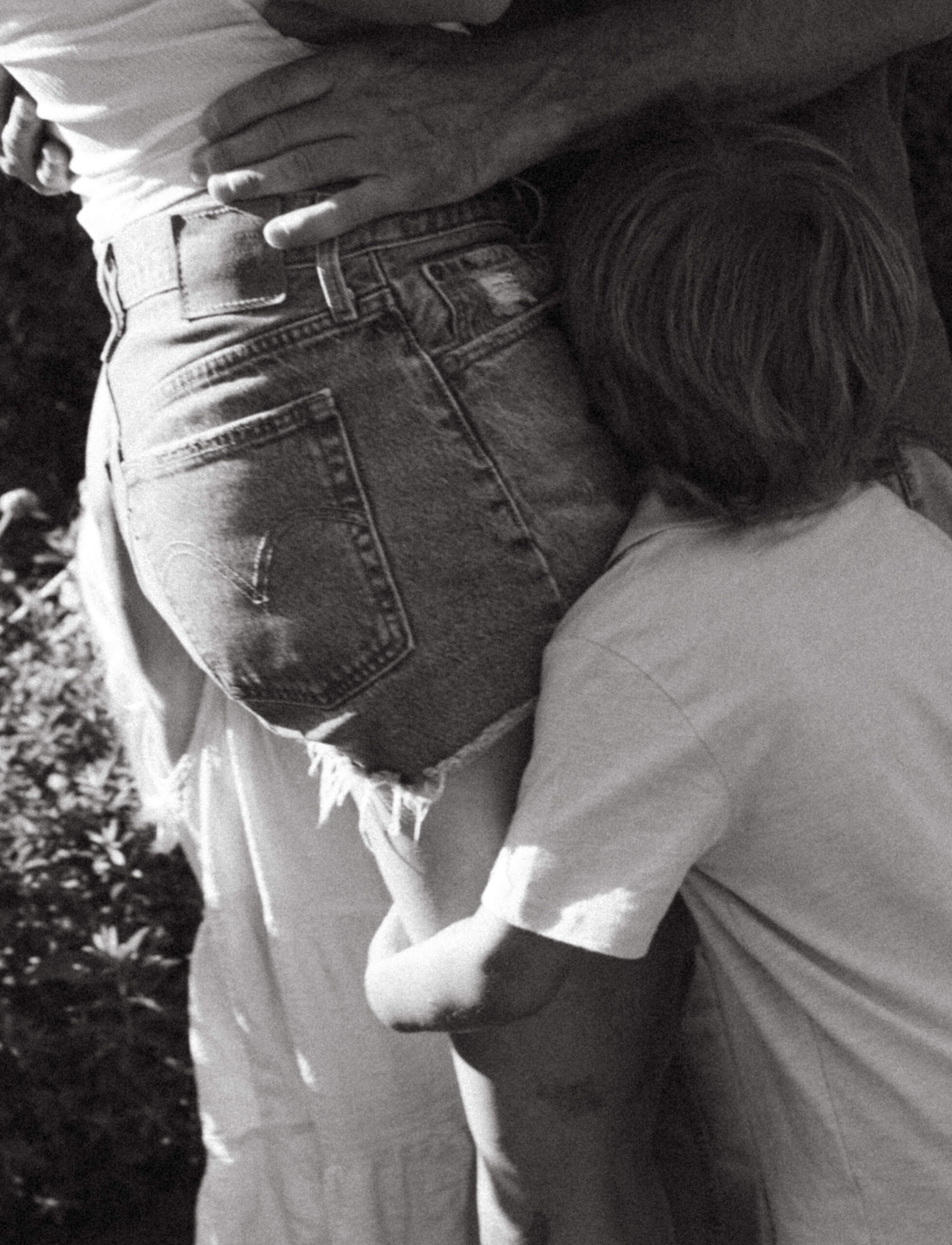 little boy wraps around mothers legs during summer family session in ottawa