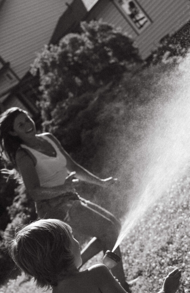 documentary style photographer captures moment of mother playing with her children in their countryside backyard 