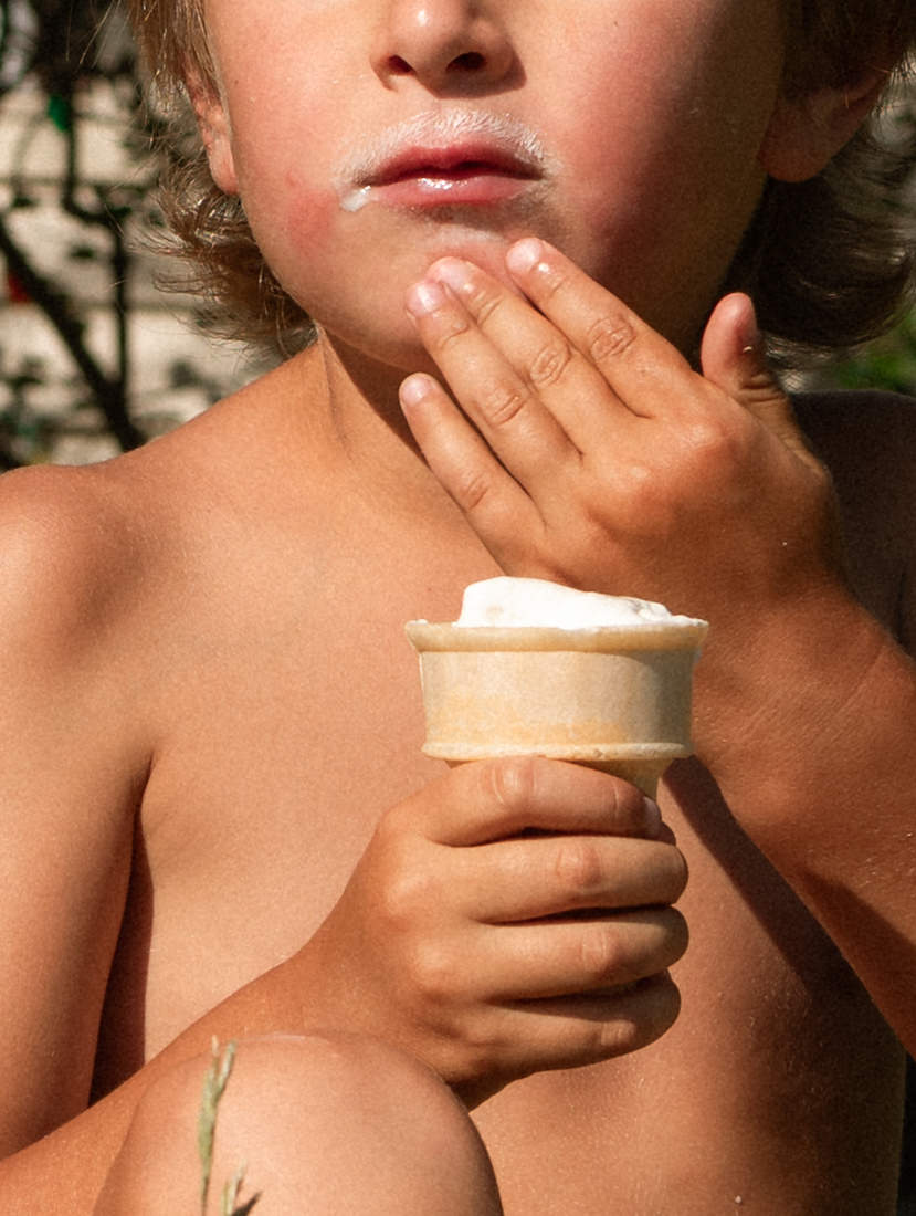 top documentary family ottawa photographer captures candid moment of little boy eating his ice cream cone with family during summer session