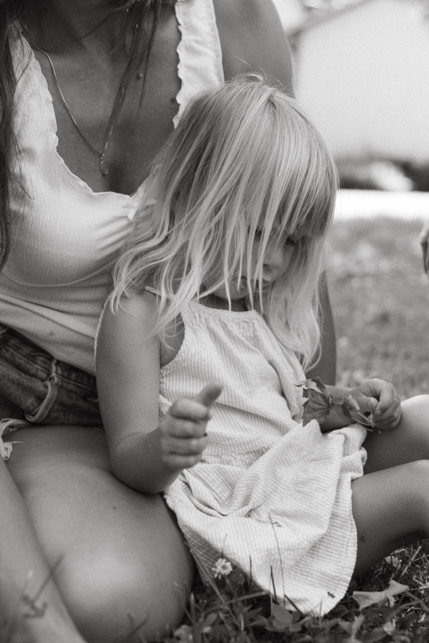 candid moment between mother and daughter as she sits between her legs during family session